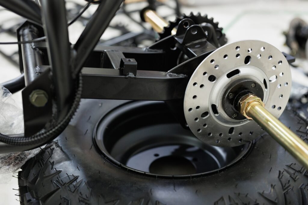 Workers are making a motorcycle in workshop. Preparing the motorcycle for sale. Wheel replacement